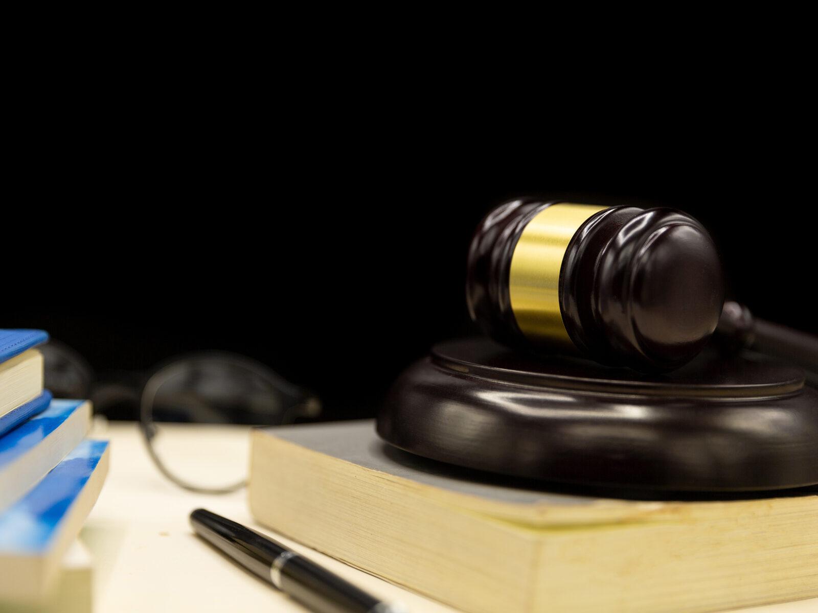 A judge's gavel resting on legal books, symbolising the firm's legal practice